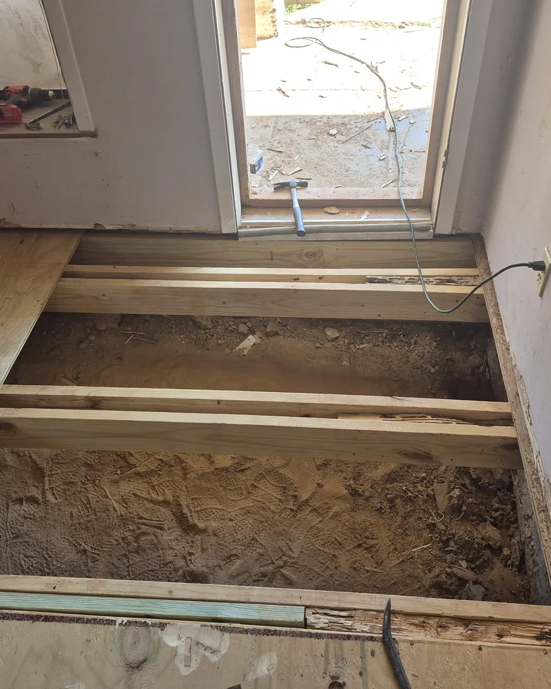 Exposed floor joists during a termite damage repair