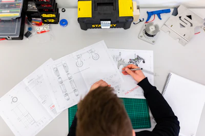 Engineer sketching a mechanical blueprint at a workbench