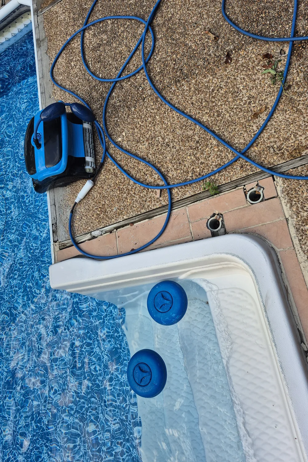 Robotic pool cleaner and cord on the deck after a service run